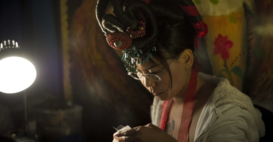 Tatuadora prepara equipamento durante a 15º Convenção de Nova York, que aconteceu em Manhattan, em 19 de maio -  AFP PHOTO / MLADEN ANTONOV