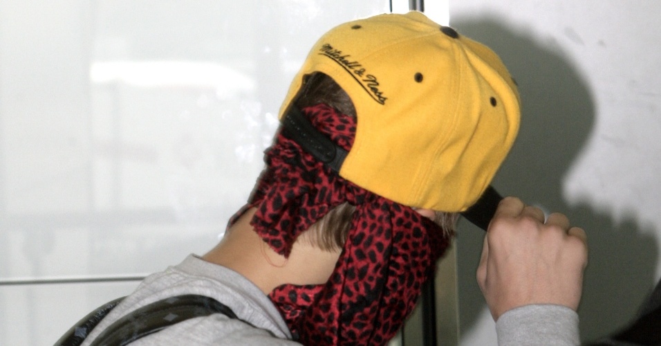 Depois de confusão com fotógrafo, Justin Bieber usa lenço no rosto e tenta evitar flashes (29/5/12)