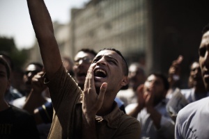 Manifestante grita palavras de ordem contra o antigo regime de Hosni Mubarak na Praça Tahrir, no Cairo