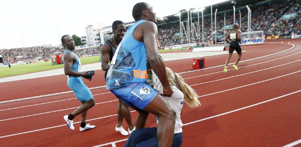 O jamaicano  Usain Bolt se choca com mulher após cruzar a linha de chegada  - EFE/ HEIKO JUNGE