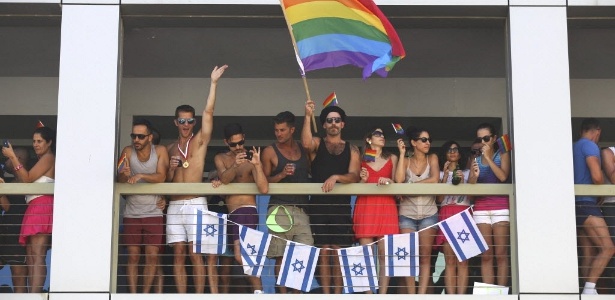 Jovem agita bandeira de arco-íris, símbolo da causa LGBT, em parada gay de Tel Aviv, Israel - Abir Sultan/Efe