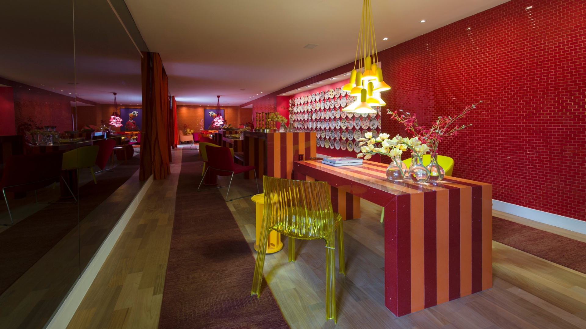 O mobiliário da alemã Kare e a iluminação da La Lampe ajudam a compor o cenário de cores intensas do Living assinado por Brunete Fraccaroli. O espaço homenageia a apresentadora Sabrina Sato. Destaque para a parede coberta por pratos estampados com caveiras e para o laranja que determina o tom da ambientação - Kátia Kuwabara/UOL