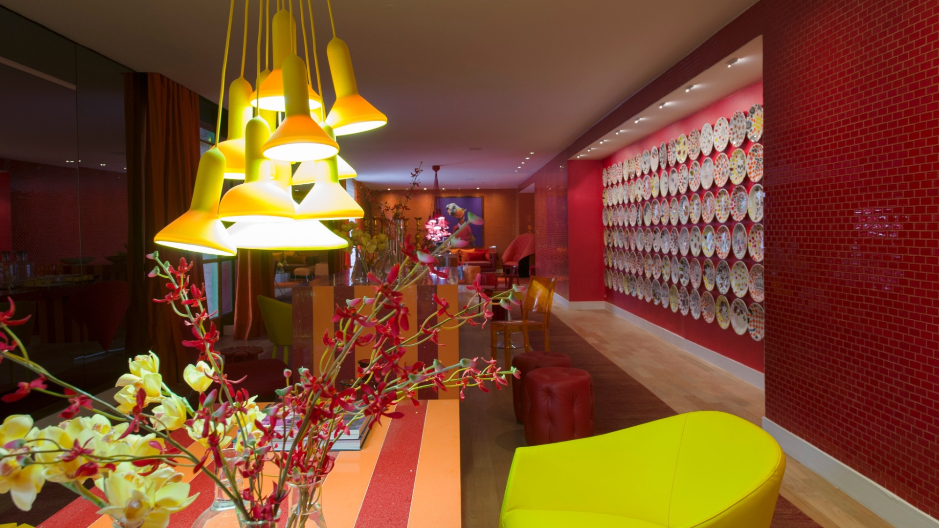 O mobiliário da alemã Kare e a iluminação da La Lampe ajudam a compor o cenário de cores intensas do Living assinado por Brunete Fraccaroli. O espaço homenageia a apresentadora Sabrina Sato. Destaque para a parede coberta por pratos estampados com caveiras e para o laranja que determina o tom da ambientação - Kátia Kuwabara/UOL