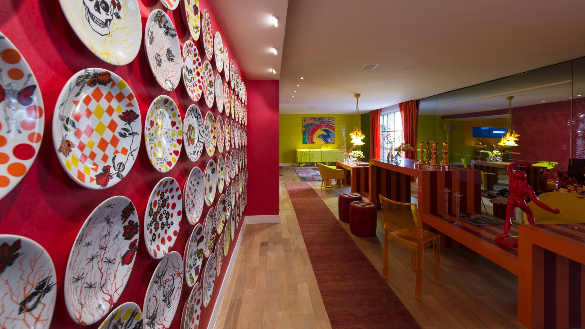 O mobiliário da alemã Kare e a iluminação da La Lampe ajudam a compor o cenário de cores intensas do Living assinado por Brunete Fraccaroli. O espaço homenageia a apresentadora Sabrina Sato. Destaque para a parede coberta por pratos estampados com caveiras e para o laranja que determina o tom da ambientação - Kátia Kuwabara/UOL