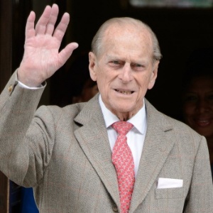 O príncipe Philip acena para o público ao deixar o hospital ontem