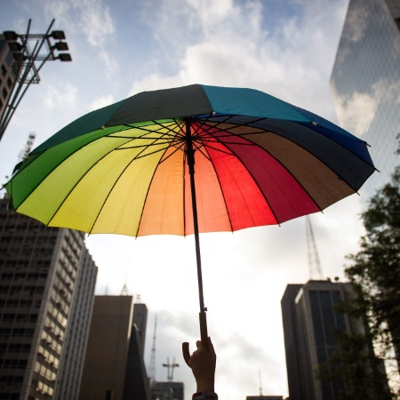 9.jun.2012 - Participante de caminhada ergue guarda-chuva colorido com as cores da bandeira do movimento gay. Realizada desde 2002, a caminhada tem como objetivo protestar contra o preconceito a diversidade sexual - Yasuyoshi Chiba/AFP