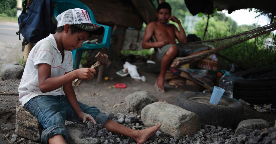 12.jun.2012 - Menino de 9 anos usa martelo para quebrar pedras em estrada para Mazatenango, na Guatemala