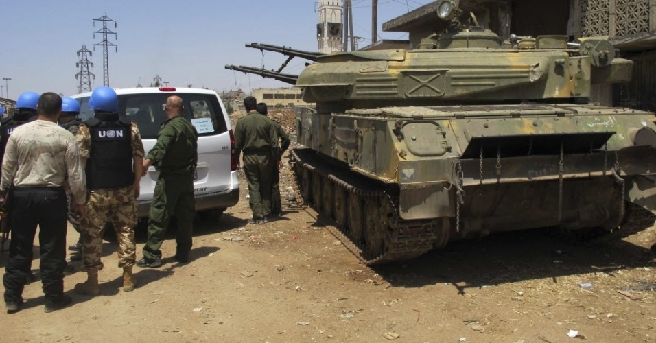 12.jun.2012 - Observadores da ONU (Organização das Nações Unidas) inspecionam posição militar do governo sírio guarnecida com tanque em Homs, nesta terça-feira (12)