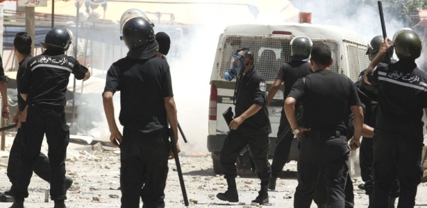 Policiais perseguem manifestantes em Túnis, capital da Tunísia