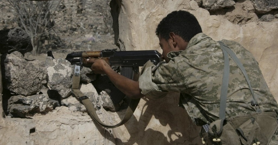 12.jun.2012 - Soldado do exército do Iêmen se posiciona para atirar durante conflito com militantes da Al Qaeda perto de Zinjibar. O governo do país árabe expulsou combatentes ligados ao grupo terrorista de dois de seus principais territórios nesta terça-feira (12), depois de semanas de confronto