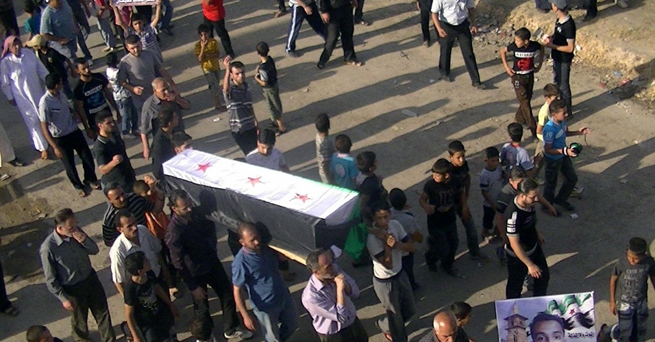 12.jun.2012 - Sírios carregam caixão com o corpo de um companheiro morto por forças de segurança leais ao ditador Bashar al Assad em Deraa, perto da fronteira síria com a Jordânia