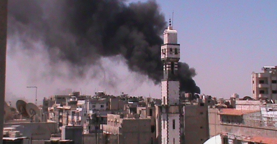 13.jun.2012 - Fumaça sobe do vilarejo de Al Khalidieh, perto de Homs, na Síria
