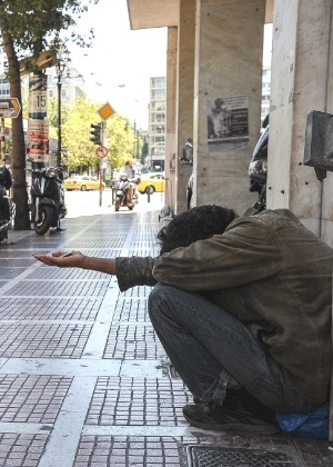 Morador de rua pede esmola em rua de Atenas, capital da Grécia