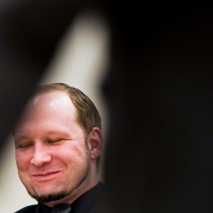 O autor do massacre de julho de 2011 na Noruega, Anders Breivik, sorri enquanto escuta uma equipe de psiquiatras defender um relatório médico em seu julgamento em Oslo - Vegard Groett/EFE