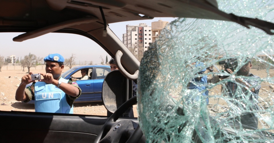 14.jun.2012 - Oficial da ONU fotografa veículo que foi atingido após a explosão de um carro-bomba, em Damasco, na Síria