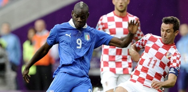 Alvo de ofensas racistas, Balotelli divide a bola com o croata Darijo Srna