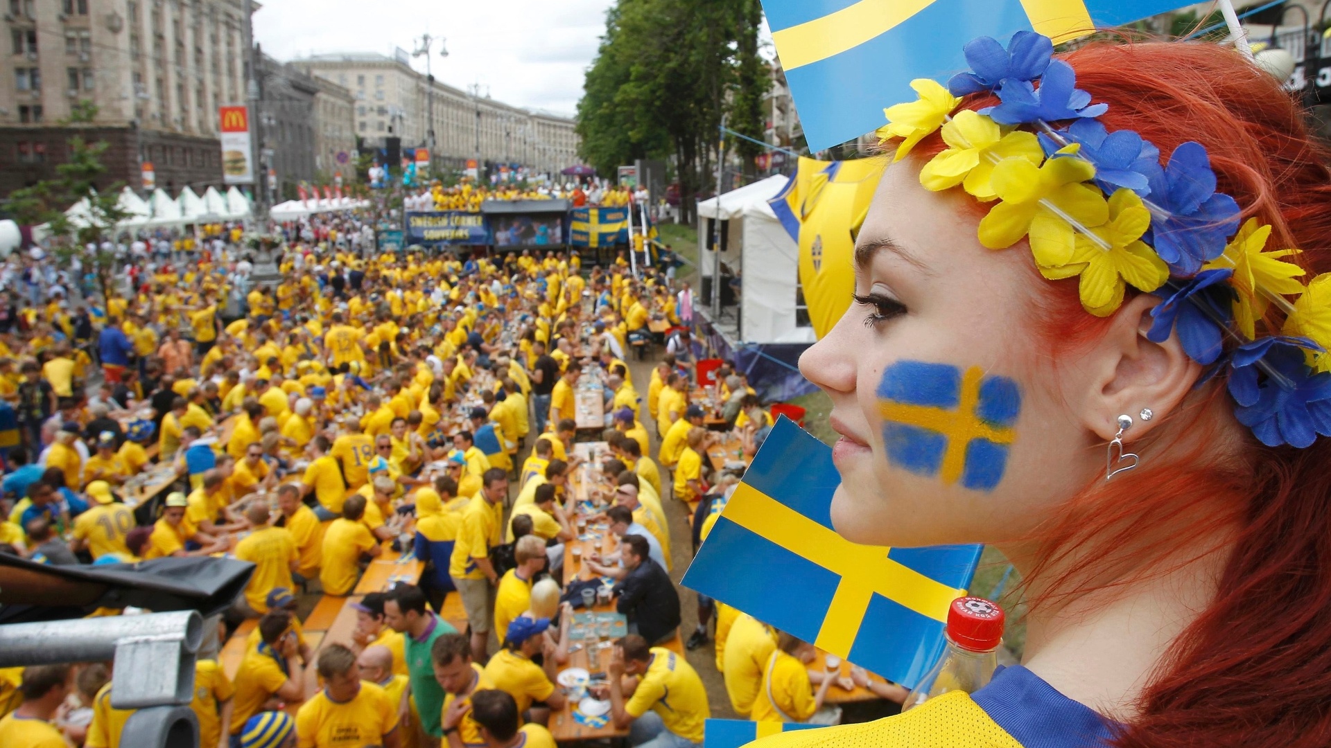 15.jun.2012 - Bela sueca espera partida de seu país contra a Inglaterra na Eurocopa, enquanto diversos torcedores aproveitam para matar a fome