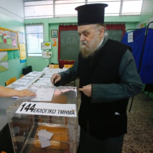 Sacerdote ortodoxo lança seu voto em escola em Atenas, na Grécia, neste domingo (17), durante eleições legislativas no país