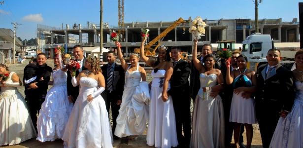 Casais posam para foto após o casamento coletivo nas obras do futuro estádio do Corinthians