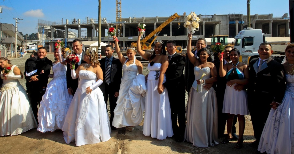 Casais posam para foto após o casamento coletivo nas obras do futuro estádio do Corinthians