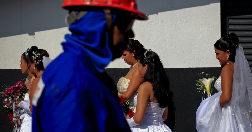 Operário passa em frente à fila de noivas, no canteiro de obras do Itaquerão