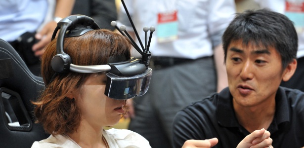 Visitante experimenta o óculos de realidade virtual da Canon em feira que acontece em Tóquio - Yoshikazu Tsuno/AFP