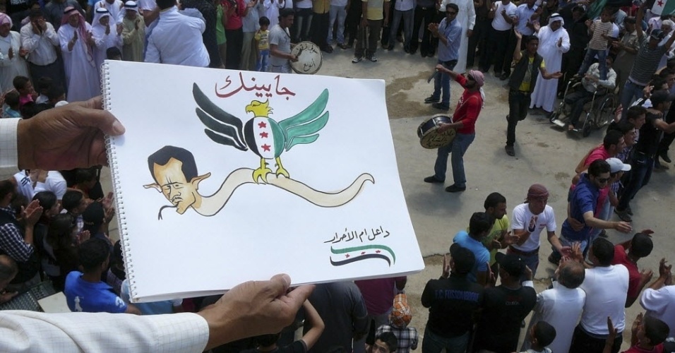 22.jun.2012-Manifestante mostra desenho de Bashar al Assad representado como uma cobra  em protesto contra o ditador sírio em Dael, na Síria