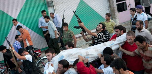 Combatentes sírios atiram para cima durante funeral; tiros representam ameaça - AFP