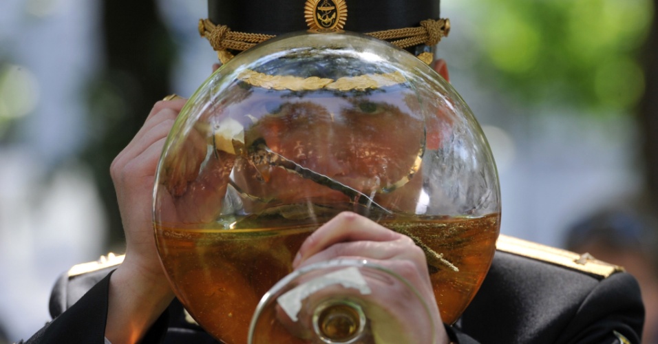 23.jun.2012 - Um tenente russo comemora sua formatura tomando vinho em uma enorme taça em São Petersburgo