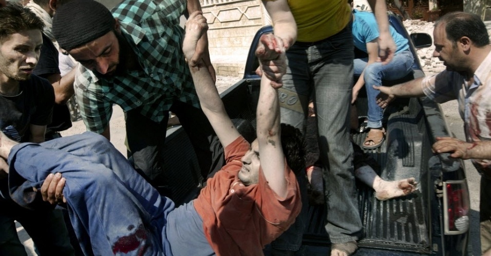 25.jun.2012 - Sírios carregam homem ferido após ataque de forças do regime em al-Qusayr, próximo à cidade de Homs.