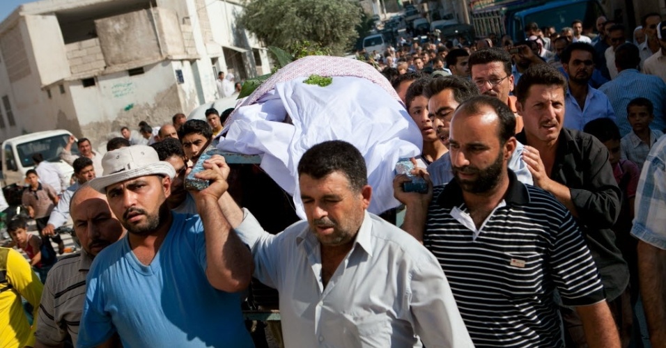 27.jun.2012 - Sírios carregam o corpo de Mustafa Mahmud Badawi, 68, morto a caminho do dentista por um atirador do Exército, na província de Idlib