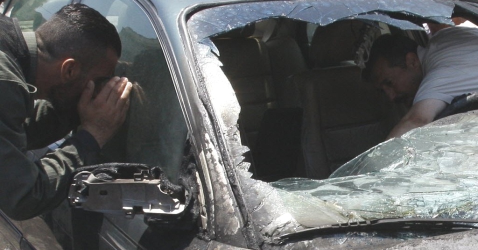 28.jun.2012 - Soldado revista carro destruído em local de explosão próximo a fórum em Damasco