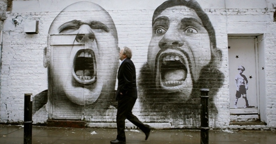 O britânico Ben Slow, que mora em Londres, diz procurar retratar o ambiente urbano e as ''pessoas que habitam a cidade que amo''. Nesta obra sem título em Hanbury Street, no leste da cidade, perto de Brick Lane, ele põe lado a lado um skinhead com um muçulmano de origem asiática, como que destacando os extremos da vida urbana britânica (27/6/12) - BBC Brasil