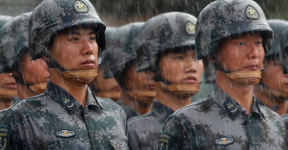 29.jun.2012 Soldados do Exército Popular de Libertação em posição de sentido na chuva pesada durante um desfile militar, antes da chegada do presidente chinês Hu Jintao na base aérea de Shek Kong, em Hong Kong