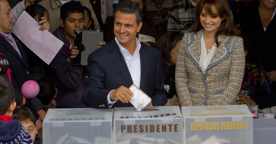 1.jul.2012 - Candidato do Partido Revolucionário Institucional, opositor ao governo atual, Enrique Peña Nieto (centro) vota acompanhado da mulher Angelica Rivera, em Atlacomulco, México