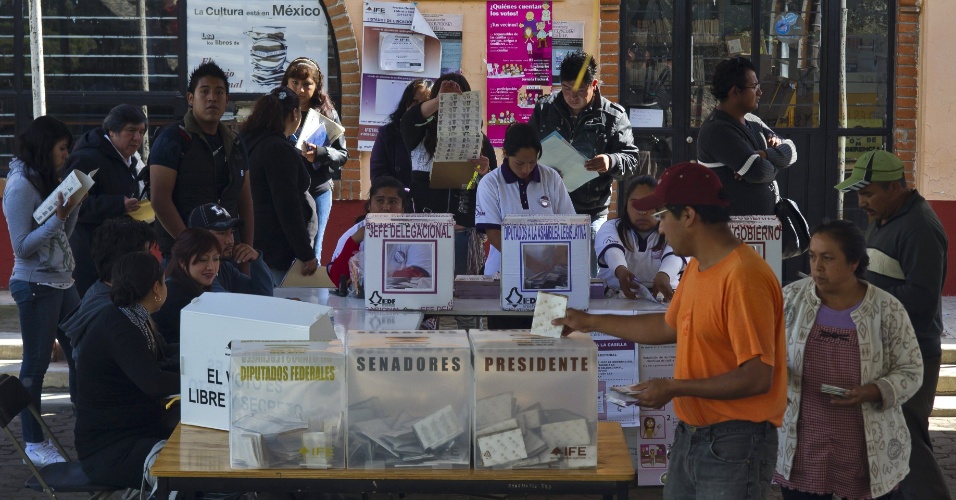 1.jul.2012 - Cidadãos depositam voto em urnas em centro de votação na Cidade do México. Cerca de 80 milhões de mexicanos devem votar neste domingo em 143 mil colégios eleitorais 
