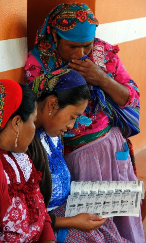 1.jul.2012 - Mulheres checam informações sobre locais de votação em San Bartolome Quialana, na periferia de Oaxaca. Cerca de 80 milhões de mexicanos devem votar neste domingo em 143 mil colégios eleitorais   