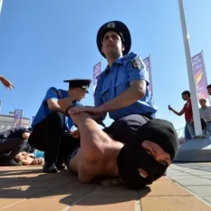 Ativista do Femen é detida após protesto realizado em frente ao Estádio Olímpico de Kiev, palco da final da Euro-2012 - SERGEI SUPINSKY/AFP
