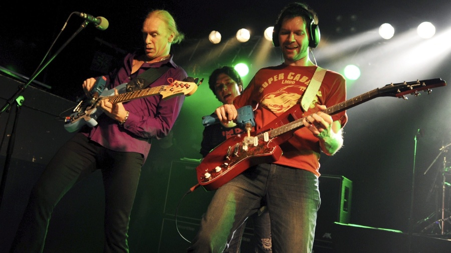 O vocalista Eric Martin (ao fundo) observa o guitarrista Paul Gilbert (à dir.) e o baixista Billy Sheehan - Tobias Hase/EFE