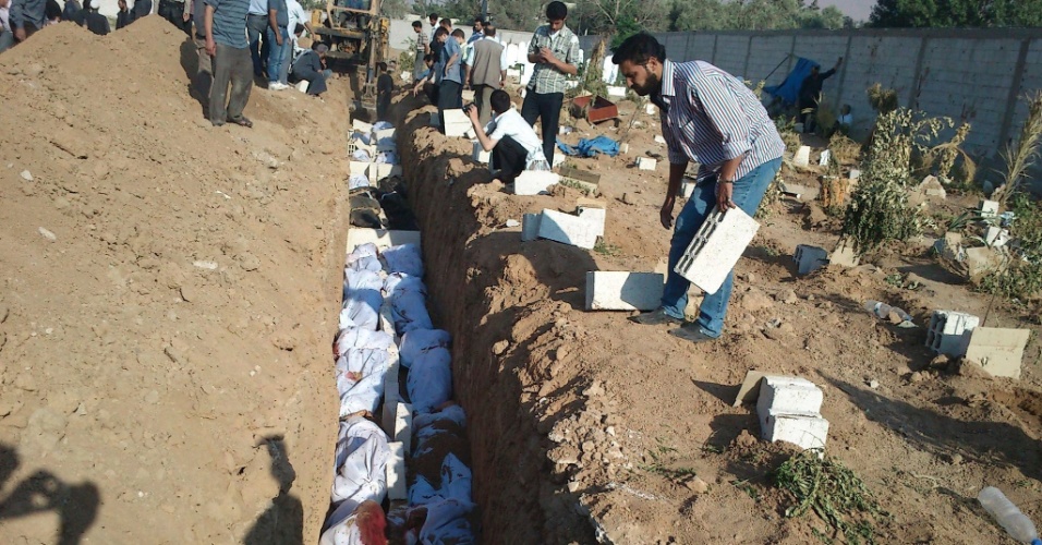 04.jul.2012 - Imagem de 30 de junho divulgada nesta quarta-feira (4) mostra sírios enterrando o corpo de pessoas mortas em um bombardeio das forças leais ao presidente Bashar al-Assad, em Donna