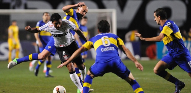 Paulinho tenta passar pela forte marcação dos jogadores do Boca Juniors no Pacaembu - Júnior Lago/Reuters