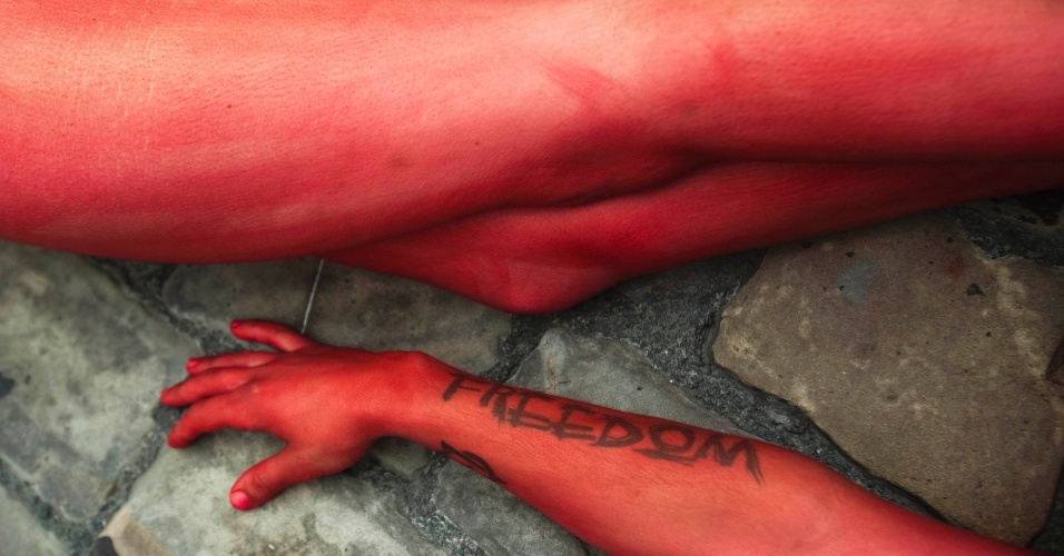 05.jul.2012 Manifestantes dos direitos dos animais cobertos de sangue falso, formam as palavras "Pare com touradas" durante um protesto pedindo a abolição das corridas de touros e touradas de San Fermin, em Pamplona