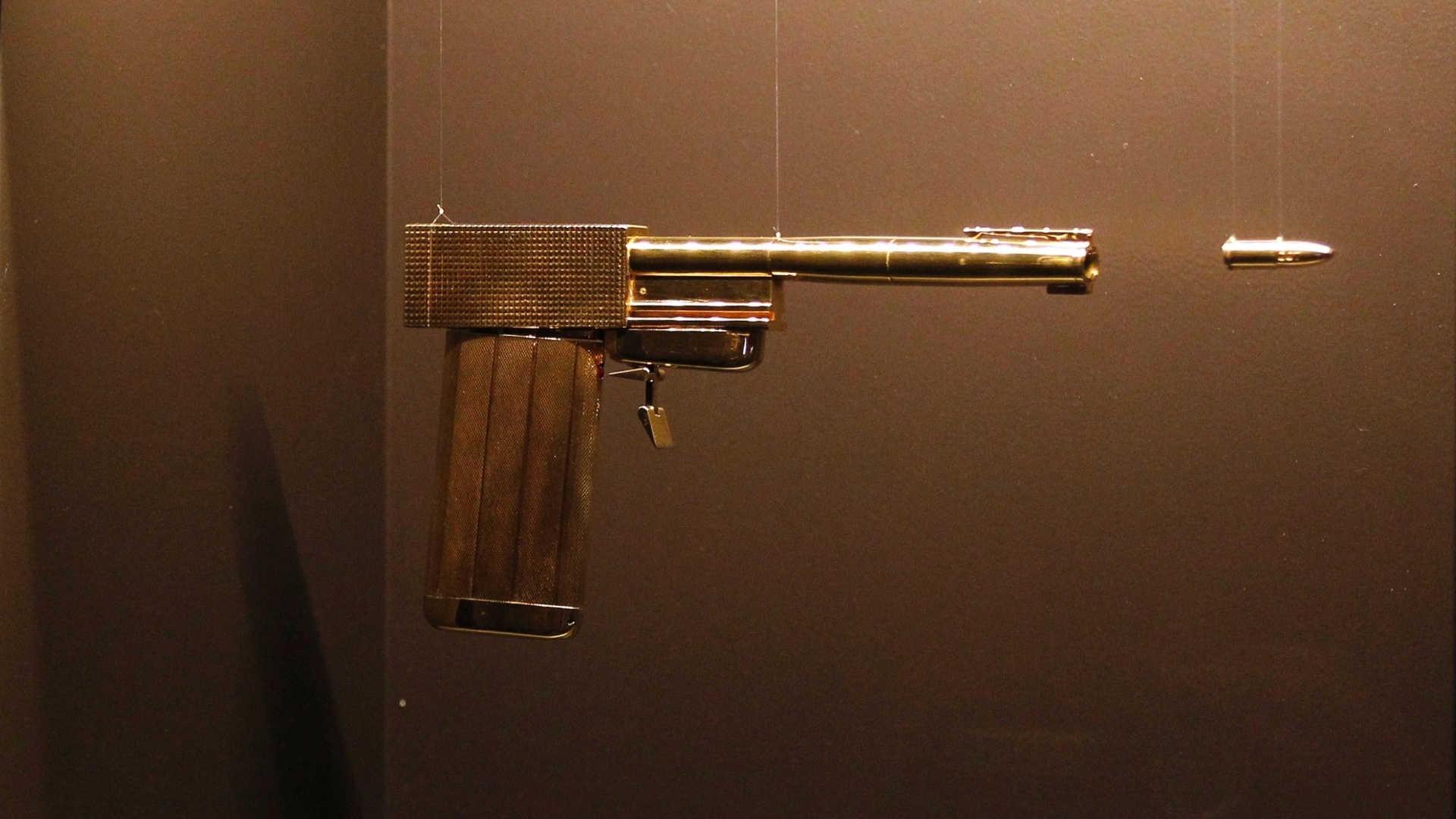 A pistola de ouro usada em "007 contra o Homem da Pistola de Ouro" de 1974, é uma das peças expostas na exposição em homenagem aos cinquenta anos da saga 007, no centro Barbican, em Londres, a partir desta quinta-feira (5)  - AP