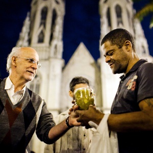 Padre Júlio Lacenlotti entrega sopa a morador de rua durante protesto contra possível proibição da distribuição de alimentos em SP - Leonardo soares/UOL