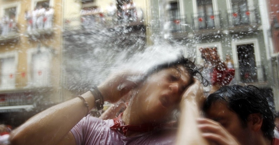 6.jul.2012 - Folião toma banho com água jogada de sacada na cidade de Pamplona, na Espanha, durante a festa de São Firmino