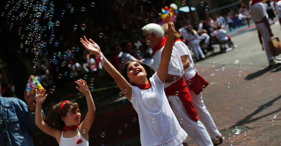 7.jul.2012 - Meninas brincam com bolhas de sabão durante a festa de São Firmino, em Pamplona, na Espanha 