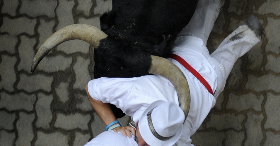 8.jul.2012 - Touro empurra homem com o chifre durante corrida dos touros, tradicional e polêmico evento da festa de São Firmino, em Pamplona, na Espanha