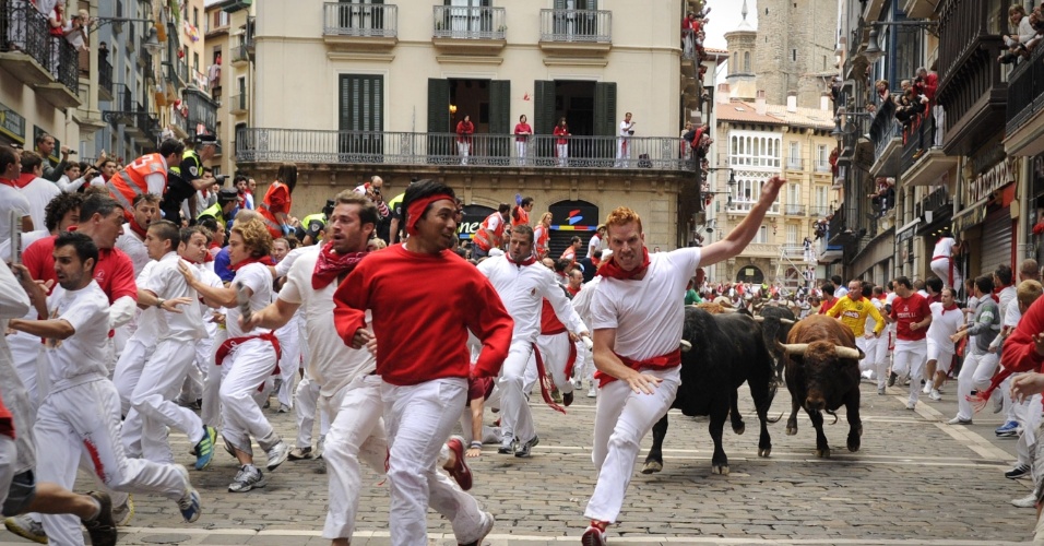 10.jul.2012 - Corredores tentam fugir de touros durante corrida tradicional da Festa de São Firmino, realizada na cidade espanhola do norte de Pamplona. O festival é um símbolo da cultura espanhola, que atrai milhares de turistas, apesar da condenação pesada de grupos de direitos dos animais