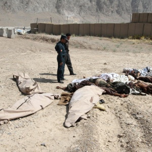 Membros da força de segurança afegã observam corpos de militantes do Taleban mortos em Kandahar
