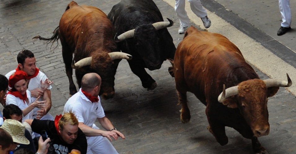 10.jul.2012 - Três touros se aproximam de corredores durante corrida tradicional da Festa de São Firmino, realizada na cidade espanhola do norte de Pamplona. O festival é um símbolo da cultura espanhola, que atrai milhares de turistas, apesar da condenação pesada de grupos de direitos dos animais